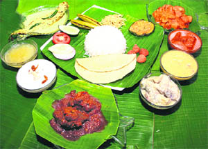 A thali with luchi and fried potoler dorma (stuffed and fried parwal)and beguni (fried brinjal, cholar daal (chana dal) etc accompanied by pabda fish in mustard sauce, kosha mangsho (mutton curry) and payesh (rice pudding or kheer)