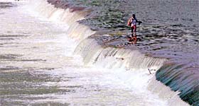 A villager wades through the Tawi to see a doctor on the other side of the river in Jammu on Saturday.