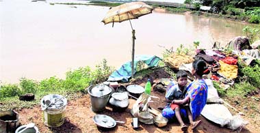 Villagers of Orissas Jajpur district prepare food as they take shelter on the banks of the Baitarani river on Sunday after the recent floods.
