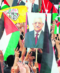 Thousands of cheering Palestinians welcome their President Mahmud Abbas (poster) at his Ramallah headquarters upon his return from delivering a historic UN membership bid on Sunday