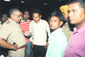 Sector-19 SHO Sukhbir Rana checks the mobile phone of Pushkar Singh at the Government Medical College and Hospital in Sector 32 of Chandigarh on Monday. 