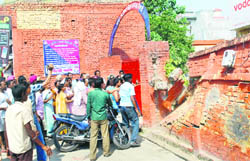 Protesters demolish the wall of the Lohian Khas police station