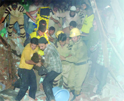 People carry an injured person out of the building that collapsed in Chandni Mahal in Old Delhi on Tuesday night