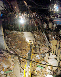 Fire department officials remove debris of the building that collapsed
