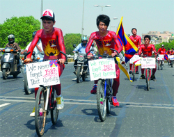 Tibetan students of Delhi University, with their bodies painted, ride bicycles during their half-naked cycle rally to protest against the Chinese authorities in Tibet and to commemorate the Tibetans' uprising in Lhasa on September 27, 1987, in New Delhi on Tuesday