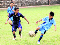 Players of Aryan School (in dark blue) and Guru Nanak Academy ( in light blue) vie for the ball in a match in the Inter-council School Sub-junior Boys Football Tournament in Dehradun on Tuesday.