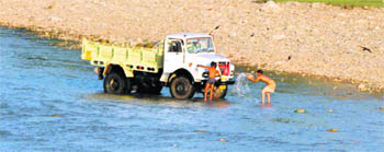 Despite a ban, washing of vehicles in the Tawi goes on unchecked. 