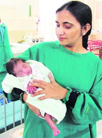 An employee caresses the abandoned baby girl at BL Memorial Kapoor Hospital in Ludhiana on Tuesday