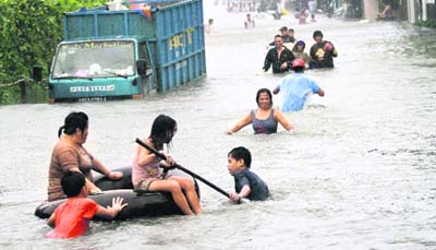 Residents wade through waist-high floodwaters brought by Typhoon Nesat, locally known as Pedring, that hit Tanza town, north of Manila. Typhoon Nesat crossed the Philippines main island late on Tuesday, flooding roads and villages, snapping power supplies and leaving behind at least seven dead. 