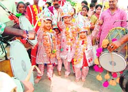 Children dressed as langoors dance on the beats of dhol during Langoor Mela in Durgiana Temple in Amritsar on Wednesday. 