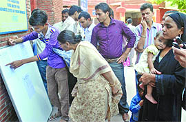 Relatives of the victims check the list outside the LNJP Hospital in New Delhi on Wednesday.