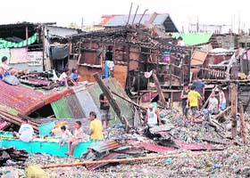 Trail of Destruction: A day after Typhoon Nesat battered Manila, residents rummage through what is left of their shanties, on Wednesday