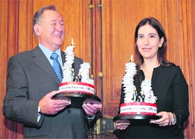 French comic book illustrator and scriptwriter Albert Uderzo (left) and Anne Goscinny, daughter of Rene Goscinny who was the co-writer of the comic book series, pose with trophies to mark the 350 millionth copy of the 34 Asterix books sold worldwide, in Paris