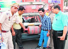 District Food and Civil Supplies officials and the traffic police remove a domestic LPG cylinders from a car in Amritsar on Thursday