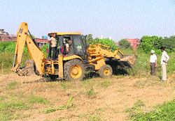 A JBC machine uproots weeds from the Civil Hospital