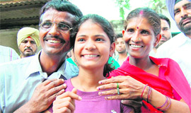 A beaming Pooja with her jubiliant parents Sonu Prasad and Sumri Devi in Amritsar on Friday.
