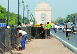Workers on Friday paint the Rajpath in New Delhi ahead of the Formula One race