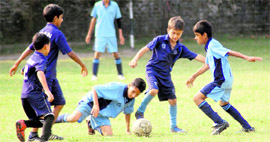 Players of Guru Nanak Academy (sky blue) and Aryan School (blue) in action in a match in the Inter-council School Sub-junior Boys Football Tournament in Dehradun on Friday.