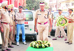 A senior CRPF officer lays a wreath on the coffin containing the body of havildar major Naval Singh in Jalandhar on Friday.