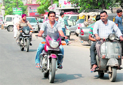 Helmet-less drivers can be seen risking their lives