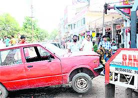 MC staff tow away an old car dumped at Burail village on Saturday. 
