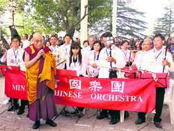 The Dalai Lama poses for photographs with the Mi Yo Chinese Orchestra group from Taiwan at the main Tibetan temple in McLeodganj, Dharamsala, on Saturday