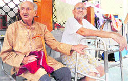 Inmates of an old-age home sit in its lobby on International Day of Older Persons in Jammu