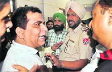 A policeman tries to pacify an irate parent at the parent-teacher meeting of Ryan International School in Ludhiana on Saturday. 
