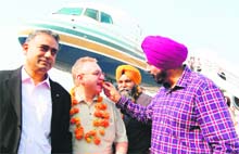 MP Navjot Singh Sidhu offers sweets to passengers alighting from the first Vienna-Amritsar flight at the Sri Guru Ram Das Airport in Amritsar on Sunday.