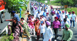 Members of the ETT Union, Punjab, cross the divider on the Barnala road while staging their protest.