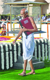 A man dressed like Gandhi pays tributes to the Mahatma at Rajghat in New Delhi on Sunday. 