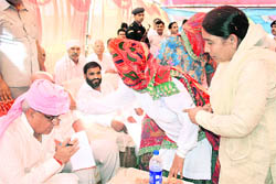 An elderly woman blesses Chief Minister Bhupinder Singh Hooda at Kuleri village in the Uklana assembly segment during campaigning on Sunday. P