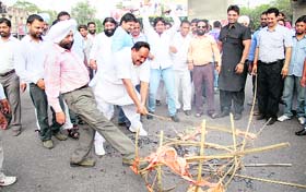 Swarn Singh, a retired IAS officer and father of Regional Passport Officer Perneet Singh along with protesters burn the effigy of the BJP at the BMC chowk in Jalandhar on Sunday