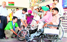 Members of the Bharat Vikas Parishad Charitable Trust distribute artificial limbs among needy persons in Ludhiana.