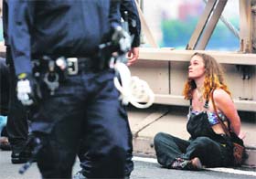 A protester looks at a police officer after being arrested on the Brooklyn Bridge in New York