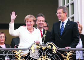 German President Christian Wulff (right) and German Chancellor Angela Merkel wave to people after their arrival at the Town Hall during celebrations marking the countrys 21st anniversary of reunification, in Bonn on Monday