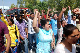 Employees of various Farad Kendras protest and block traffic near the bus stand in Bathinda on Tuesday. 