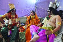 Artistes dressed up for the roles of Ravan, Sita and Meghnath wait backstage to perform in the Ramlila at the Ramlila Ground in New Delhi on Tuesday.
