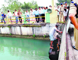 Divers take out the body of a victim from the Shakti Canal at Vikasnagar in Dehradun on Tuesday