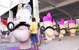 Artisans give final touches to the effigies of Ravana ahead of Dasehra in Karnal on Tuesday. 