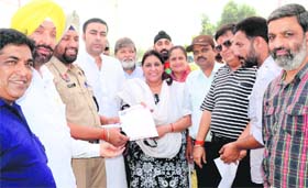 Residents and Congress leader Gurkanwal Kaur hand over a memorandum to ACP Balkar Singh in Jalandhar Cantonment on Tuesday