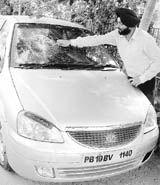 Prabhsimran Singh shows the broken glass of his Tata Indica outside his house at Bhai Randhir Singh Nagar in Ludhiana on Tuesday.
