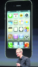 Apple CEO Tim Cook speaks in front of an image of an iPhone 4S at the Apple headquarters on Tuesday.  Reuters