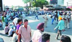 Employees of the Farad Kendras blocked road at the bus stand chowk in Bathinda on Wednesday. They were demanding regularisation of their services.