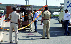 The Delhi police removes the body from the spot where a truck killed a pedestrian near Mukarba Chowk in New Delhi on Wednesday