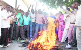Members of the Nigam Safai Mazdur Union burn an effigy of former Local Bodies Minister Manoranjan Kalia in front of his house in Jalandhar on Wednesday