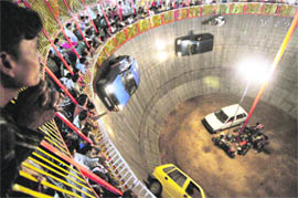 Defying death in maut ka kuanDaredevil drivers keep cars on track, firmly driving along the wall of the maut ka kuan, at the Ramlila mela in Ludhiana