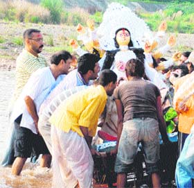 Devotees immerse an idol of goddess Durga in Ghaggar at Panchkula on Thursday.