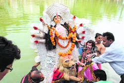 Devotees carry an idol of Goddess Durga for immersion in a pond at Tara Devi in Shimla