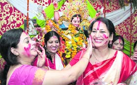 Bengali women apply vermillion on the faces of each other during the conclusion of the Durga Puja festivities in Jalandhar on Thursday
